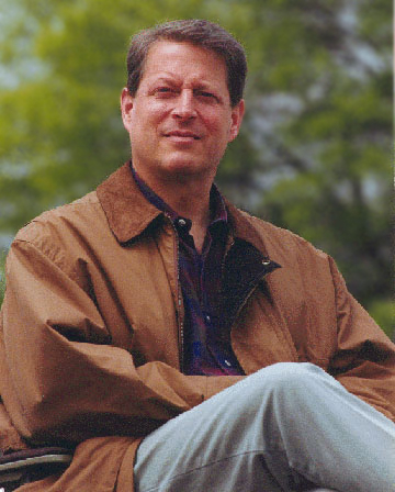 al gore in a jacket in front of greenery